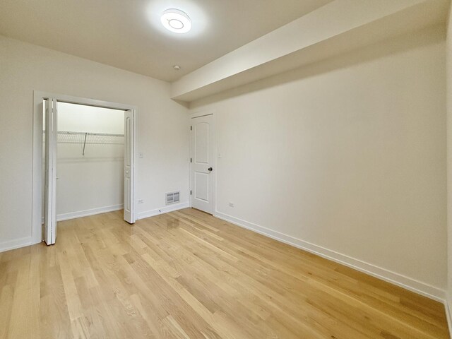4032 W Wilcox St, Chicago, IL 60624 - unfurnished bedroom with light wood-style floors, baseboards, and a closet