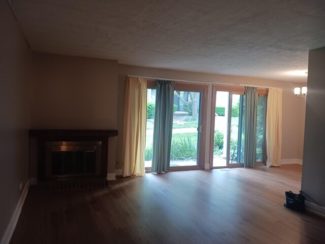 366 Pinetree Ln Unit B1, Schaumburg, IL 60193 - unfurnished living room with baseboards, wood finished floors, a glass covered fireplace, and a chandelier