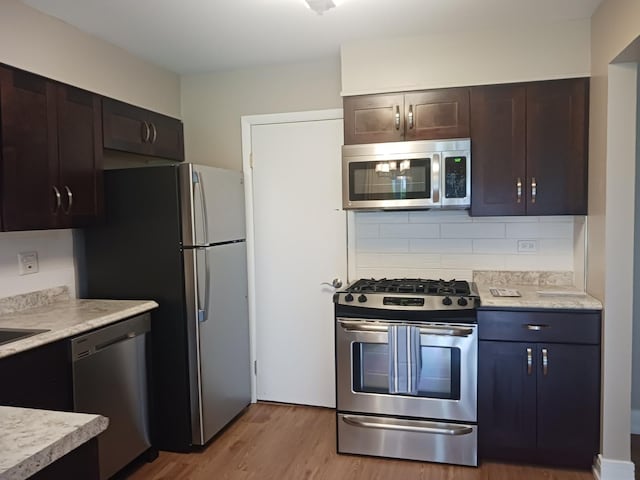 366 Pinetree Ln Unit B1, Schaumburg, IL 60193 - kitchen featuring stainless steel appliances, light wood-style floors, light countertops, tasteful backsplash, and dark brown cabinetry