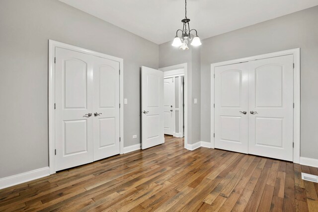 1505 N Talman Ave Unit 1, Chicago, IL 60622 - unfurnished bedroom featuring a chandelier, hardwood / wood-style floors, baseboards, and a closet