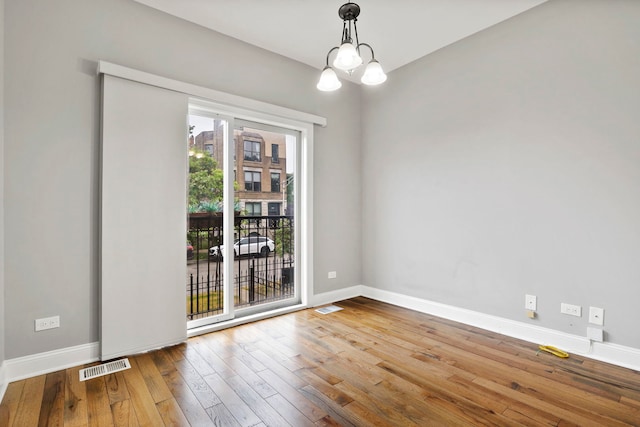 1505 N Talman Ave Unit 1, Chicago, IL 60622 - spare room featuring hardwood / wood-style floors, baseboards, and a chandelier
