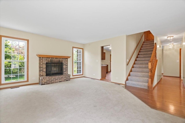 1132 10 Pin Ln, Beach Park, IL 60099 - unfurnished living room featuring plenty of natural light, stairs, baseboards, and a brick fireplace