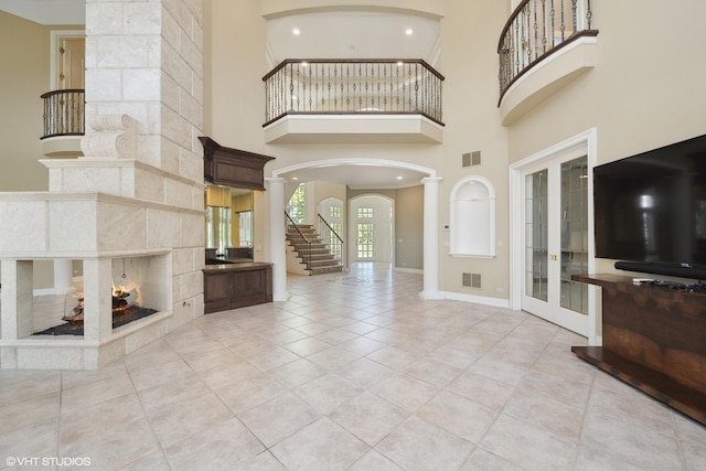 29026 N Brassie Ct, Ivanhoe, IL 60060 - foyer entrance with french doors, ornate columns, arched walkways, a fireplace, and a high ceiling