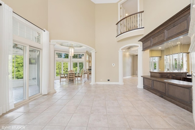 29026 N Brassie Ct, Ivanhoe, IL 60060 - spare room with ornate columns, arched walkways, a high ceiling, healthy amount of natural light, and light tile patterned floors