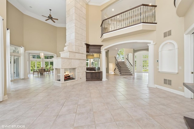 29026 N Brassie Ct, Ivanhoe, IL 60060 - unfurnished living room with decorative columns, a towering ceiling, arched walkways, a ceiling fan, and baseboards