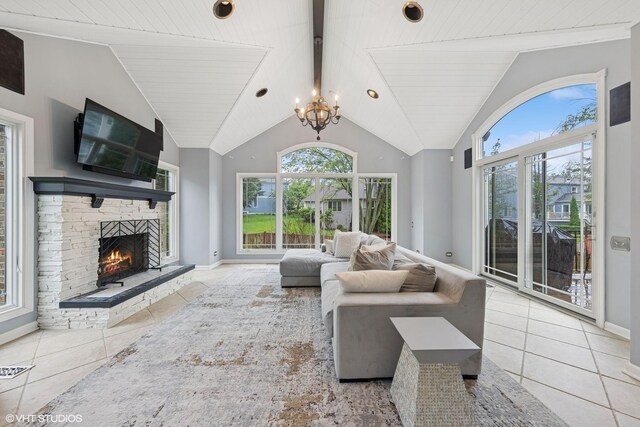 6724 Greene Rd, Woodridge, IL 60517 - tiled living area with healthy amount of natural light, a chandelier, lofted ceiling, a lit fireplace, and baseboards
