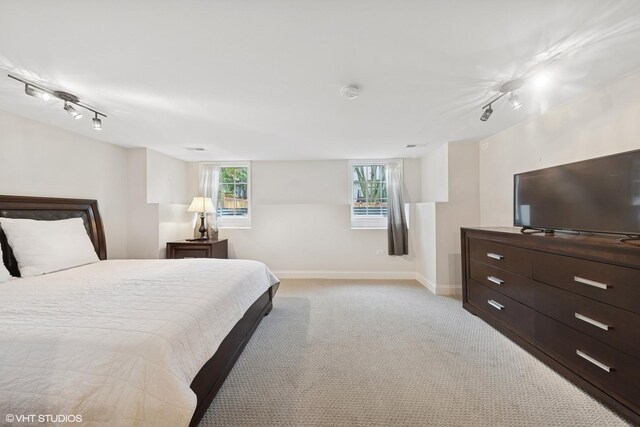 6724 Greene Rd, Woodridge, IL 60517 - bedroom with rail lighting, light carpet, and baseboards