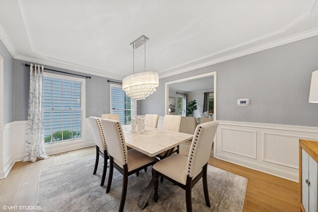 6724 Greene Rd, Woodridge, IL 60517 - dining area with a chandelier, wood finished floors, ornamental molding, a wainscoted wall, and a decorative wall
