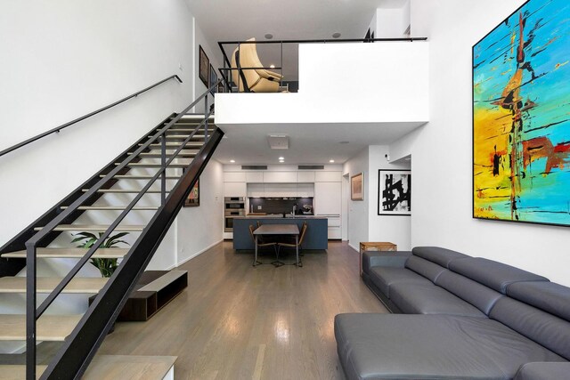 839 N Hermitage Ave Unit 101, Chicago, IL 60622 - living area featuring a towering ceiling, stairs, and dark wood-type flooring
