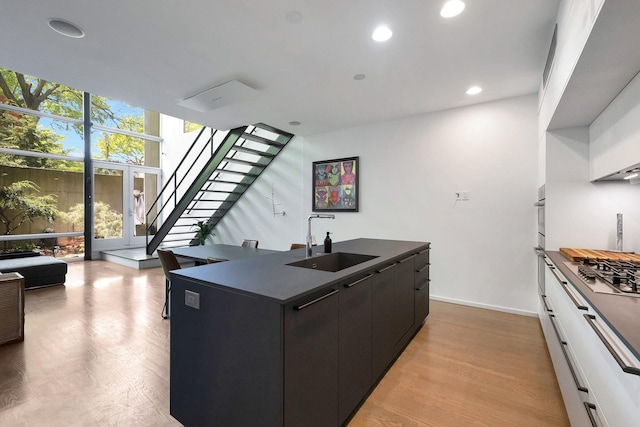 839 N Hermitage Ave Unit 101, Chicago, IL 60622 - kitchen with a sink, dark countertops, stainless steel gas stovetop, an island with sink, and recessed lighting