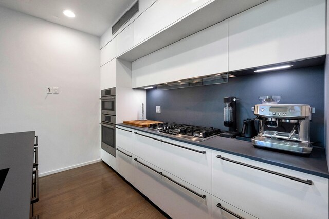 839 N Hermitage Ave Unit 101, Chicago, IL 60622 - kitchen featuring stainless steel appliances, white cabinets, dark countertops, dark wood-type flooring, and recessed lighting