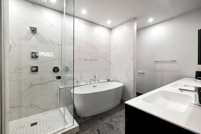 839 N Hermitage Ave Unit 101, Chicago, IL 60622 - full bathroom featuring a freestanding bath, a marble finish shower, tile walls, double vanity, and marble finish flooring