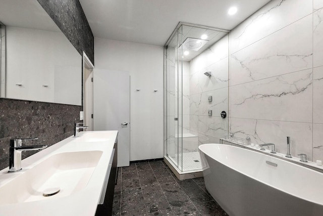 839 N Hermitage Ave Unit 101, Chicago, IL 60622 - full bathroom featuring a marble finish shower, a freestanding tub, tile walls, double vanity, and decorative backsplash