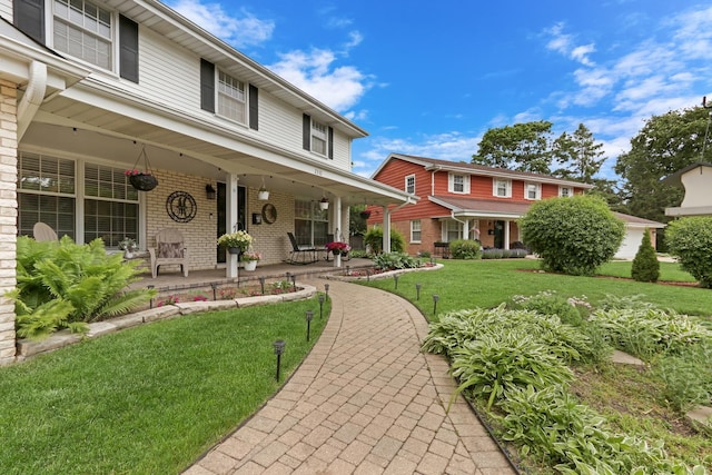 2310 Malik Ct, Glenview, IL 60025 - view of front facade with covered porch, brick siding, and a front yard