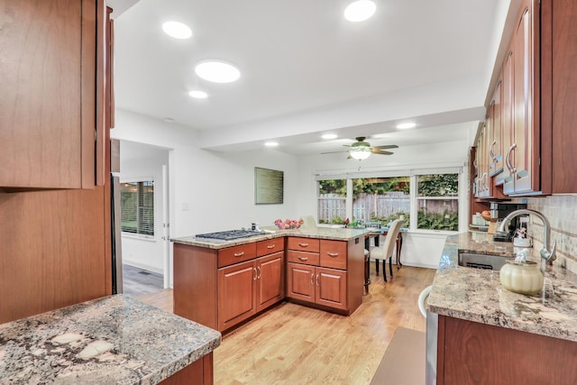 2310 Malik Ct, Glenview, IL 60025 - kitchen with light wood-style flooring, a sink, a ceiling fan, stainless steel gas cooktop, and decorative backsplash