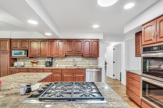 2310 Malik Ct, Glenview, IL 60025 - kitchen featuring appliances with stainless steel finishes, a sink, recessed lighting, light stone countertops, and backsplash