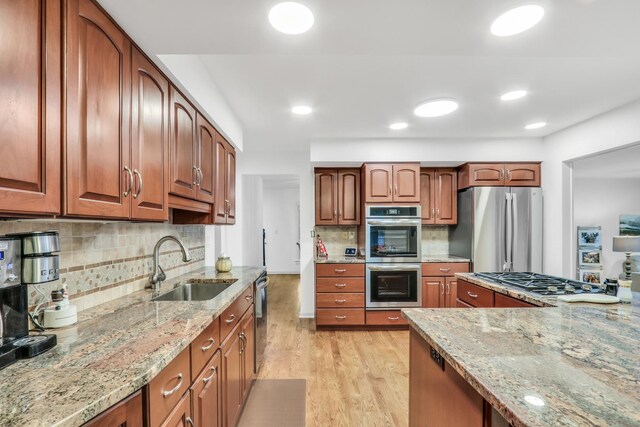2310 Malik Ct, Glenview, IL 60025 - kitchen with stainless steel appliances, a sink, light stone countertops, light wood-style flooring, and decorative backsplash