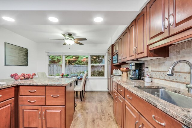 2310 Malik Ct, Glenview, IL 60025 - kitchen with a sink, ceiling fan, stainless steel microwave, light wood-style floors, and light stone counters