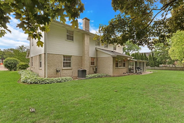2310 Malik Ct, Glenview, IL 60025 - rear view of house with a chimney, a patio, a lawn, and central AC unit