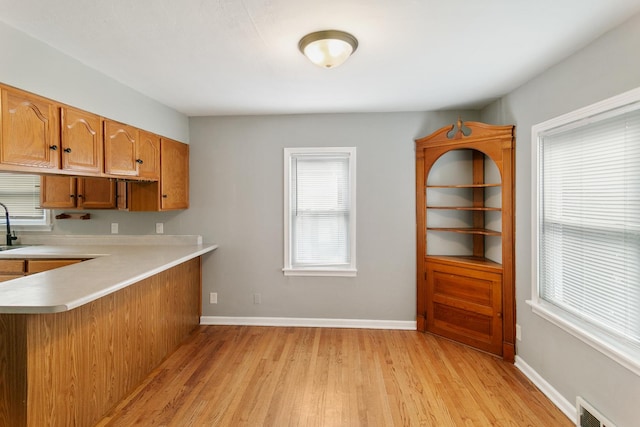 3256 186th St, Lansing, IL 60438 - kitchen with light countertops, light wood-style floors, brown cabinets, and plenty of natural light