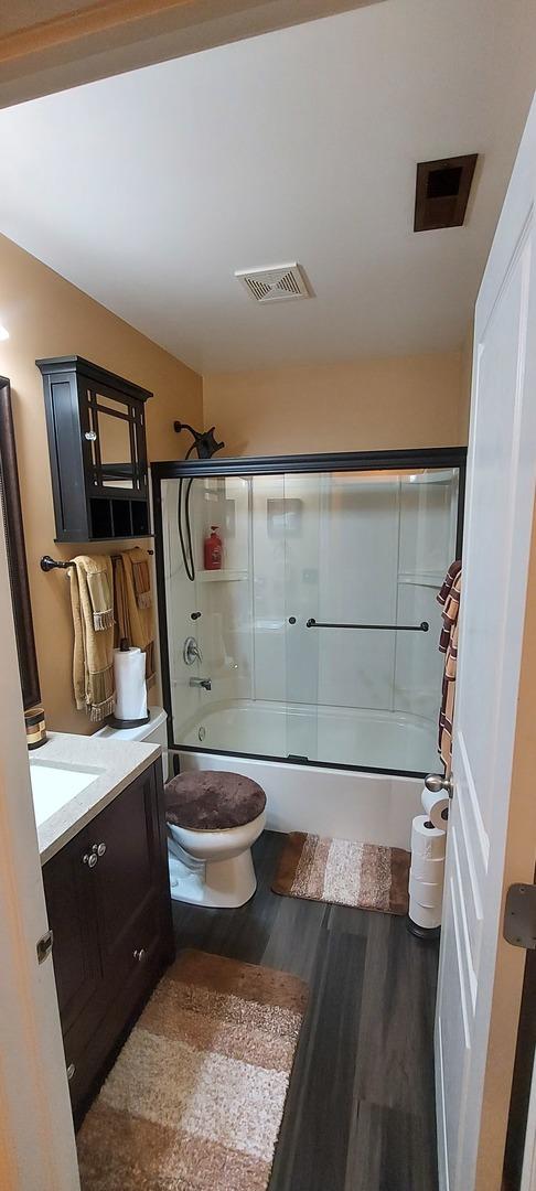 39806 Waterloo Dr, Beach Park, IL 60083 - full bath with wood finished floors, enclosed tub / shower combo, and vanity