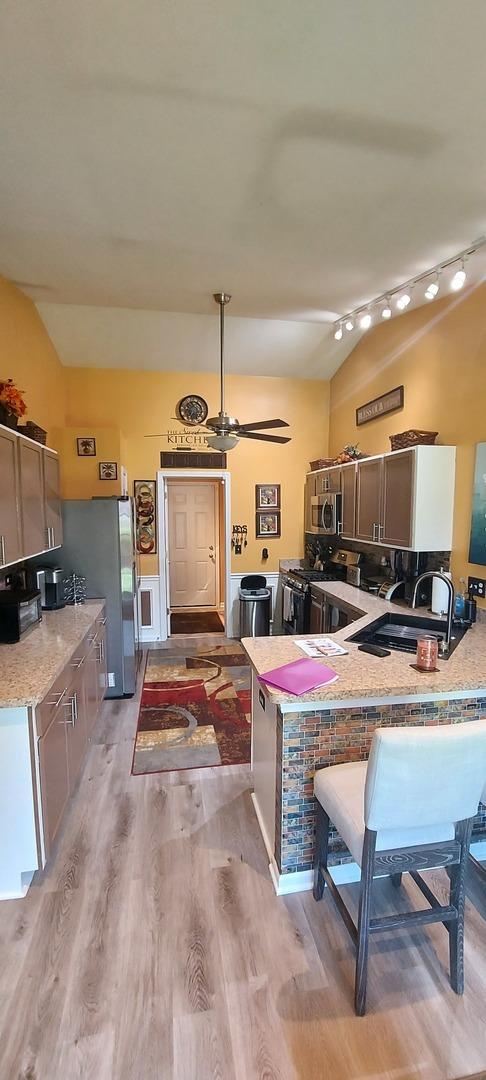39806 Waterloo Dr, Beach Park, IL 60083 - kitchen with stainless steel appliances, light wood-type flooring, ceiling fan, a peninsula, and vaulted ceiling