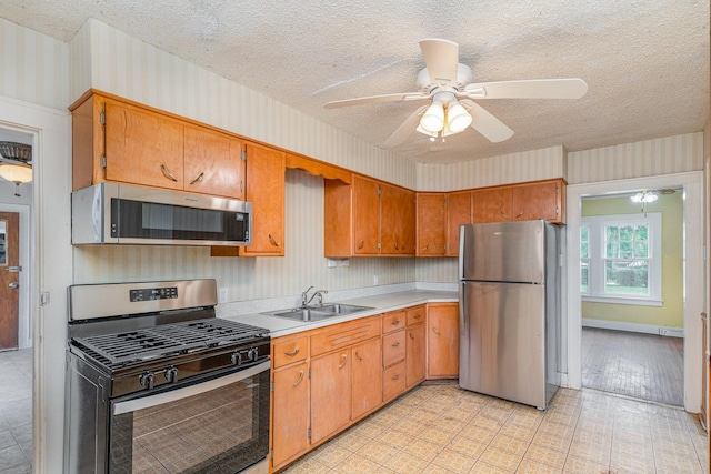 1018 Jericho Rd, Aurora, IL 60506 - kitchen featuring stainless steel appliances, a sink, wallpapered walls, a textured ceiling, and light countertops