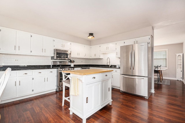 6621 W Victoria Dr, Oak Forest, IL 60452 - kitchen featuring appliances with stainless steel finishes, backsplash, white cabinetry, and dark wood-type flooring