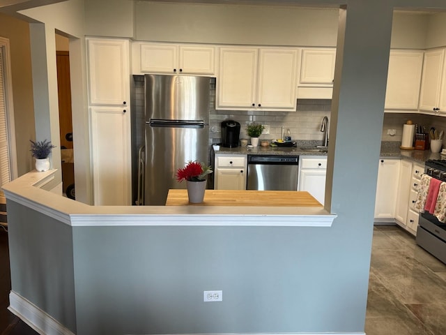 5555 N Cumberland Ave Unit 407, Chicago, IL 60656 - kitchen with stainless steel appliances, backsplash, white cabinets, a sink, and dark stone countertops