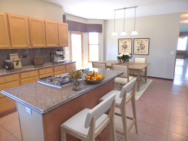 5355 Fox Path Ln, Hoffman Estates, IL 60192 - kitchen featuring stainless steel gas stovetop, a center island, a breakfast bar area, and light tile patterned flooring