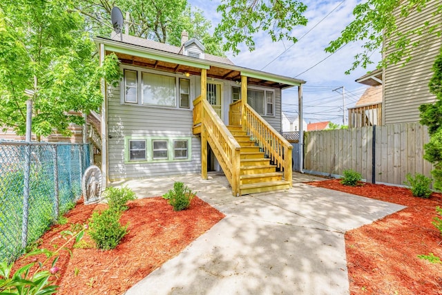 4640 S Winchester Ave, Chicago, IL 60609 - view of front facade featuring a patio area, a fenced backyard, and stairs