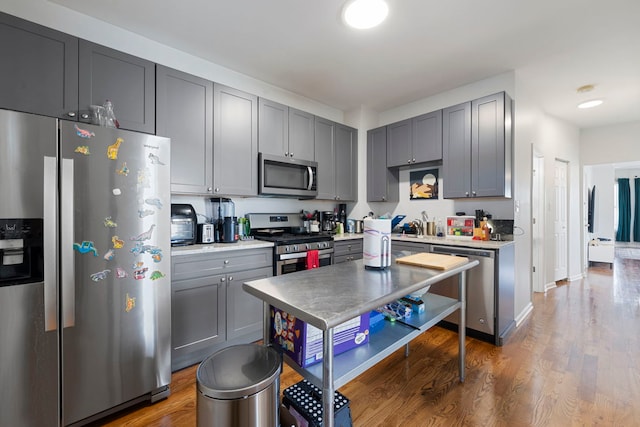 1630 N Avers Ave, Chicago, IL 60647 - kitchen with appliances with stainless steel finishes, wood finished floors, gray cabinetry, and light countertops