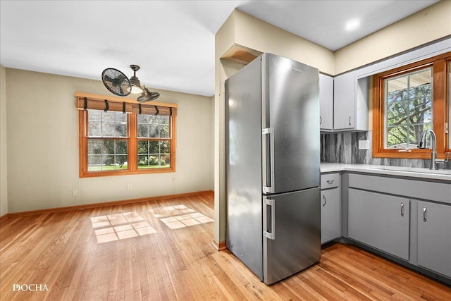 510 W Grant St, Sheridan, IL 60551 - kitchen featuring freestanding refrigerator, gray cabinetry, light wood-type flooring, light countertops, and backsplash