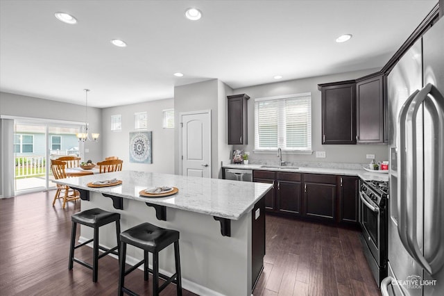794 Suffield Ct, Oswego, IL 60543 - kitchen featuring stainless steel appliances, recessed lighting, a kitchen bar, a kitchen island, and light stone countertops