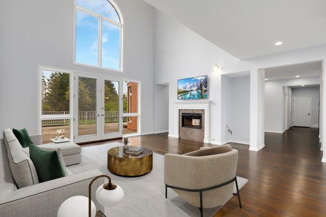 309 Dundee Rd, Barrington, IL 60010 - living area featuring wood finished floors, a towering ceiling, french doors, a fireplace, and baseboards