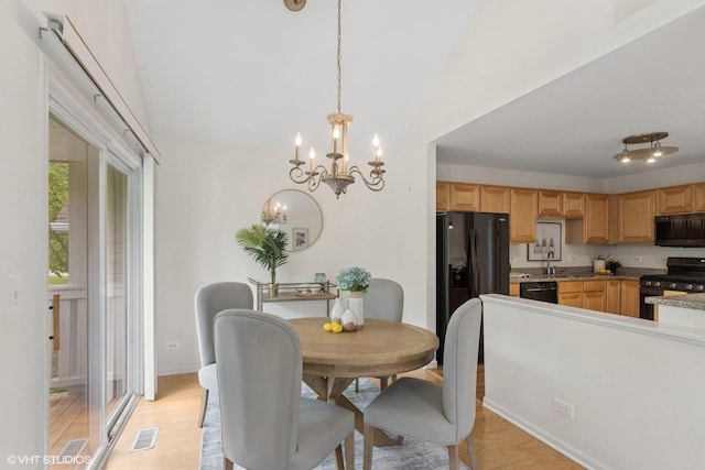 928 S Darla Ct, Waukegan, IL 60085 - dining area with a chandelier, lofted ceiling, light wood-type flooring, and baseboards