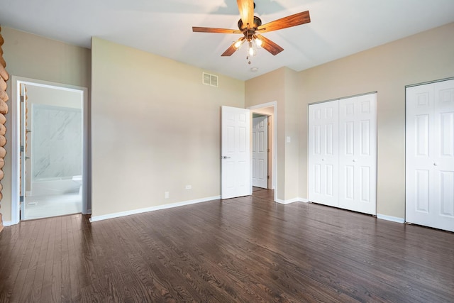189 E 34th St, Steger, IL 60475 - unfurnished bedroom featuring two closets, dark wood-type flooring, ensuite bathroom, and a ceiling fan