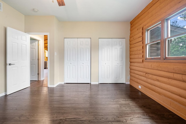 189 E 34th St, Steger, IL 60475 - unfurnished bedroom featuring multiple closets, dark wood-style flooring, rustic walls, and a ceiling fan