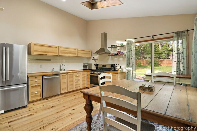 6312 Londonderry Dr, Cary, IL 60013 - kitchen featuring stainless steel appliances, island exhaust hood, light brown cabinets, a sink, and light wood finished floors