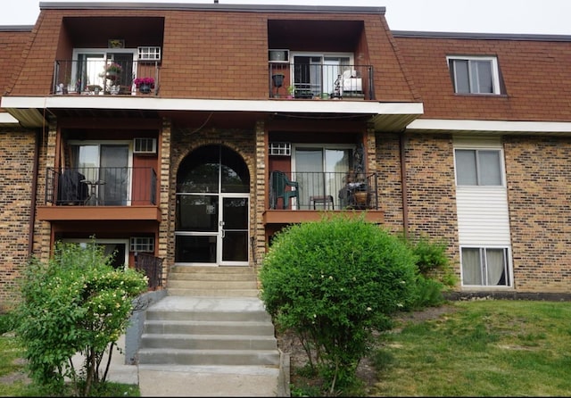 1195 Meadow Ln Unit 114, Hoffman Estates, IL 60169 - doorway to property featuring a balcony, brick siding, and mansard roof