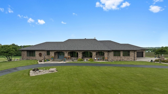 2765 W Pines Rd, Oregon, IL 61061 - french country style house featuring asphalt driveway, an attached garage, a front yard, a porch, and brick siding
