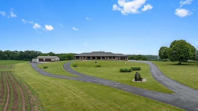 2765 W Pines Rd, Oregon, IL 61061 - view of community with asphalt driveway, a lawn, and a detached garage