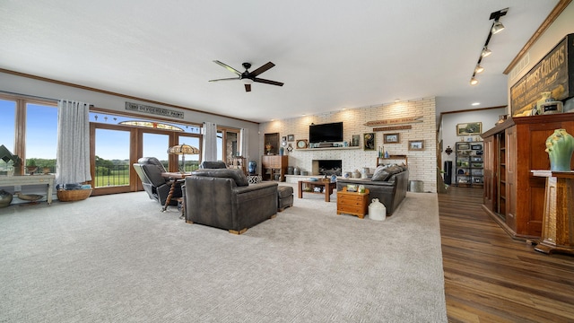 2765 W Pines Rd, Oregon, IL 61061 - living area with ceiling fan, a brick fireplace, ornamental molding, dark wood-style floors, and brick wall
