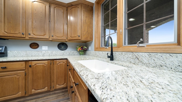 2765 W Pines Rd, Oregon, IL 61061 - kitchen featuring a sink, brown cabinetry, light stone counters, and dark wood-style floors