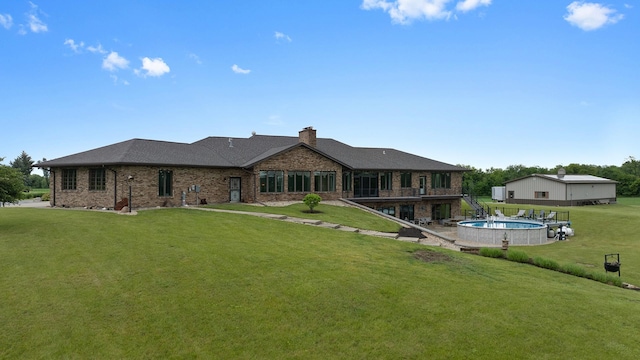 2765 W Pines Rd, Oregon, IL 61061 - back of property with a lawn, a chimney, brick siding, and an outdoor pool