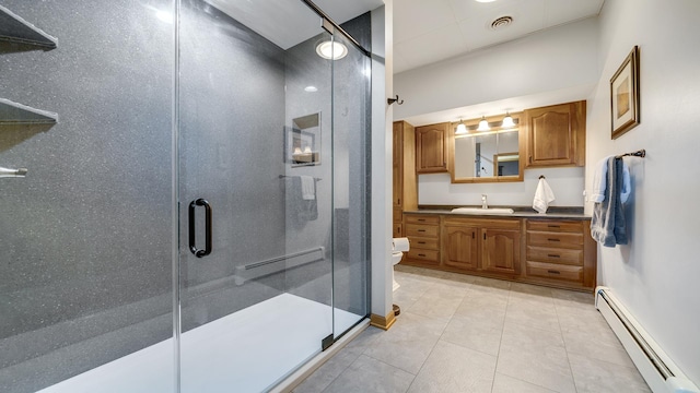 2765 W Pines Rd, Oregon, IL 61061 - bathroom with a baseboard radiator, vanity, toilet, a stall shower, and tile patterned floors