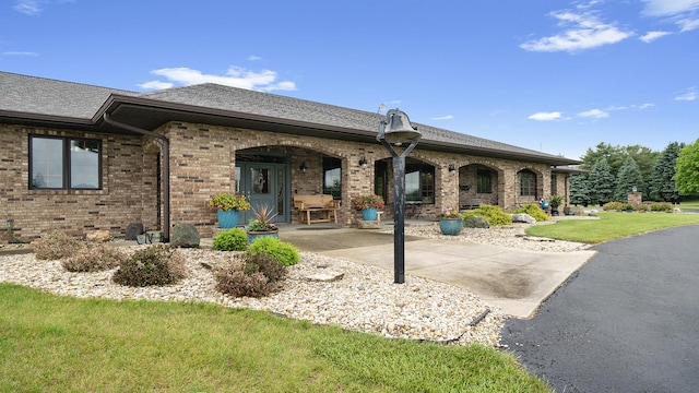 2765 W Pines Rd, Oregon, IL 61061 - rear view of house with brick siding, roof with shingles, a yard, and a patio
