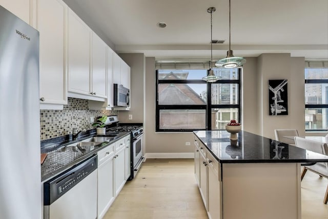 101 W Superior St Unit 501, Chicago, IL 60654 - kitchen featuring stainless steel appliances, light wood finished floors, a center island, decorative backsplash, and baseboards