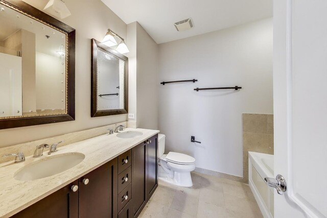 101 W Superior St Unit 501, Chicago, IL 60654 - full bathroom with baseboards, toilet, a garden tub, double vanity, and tile patterned flooring