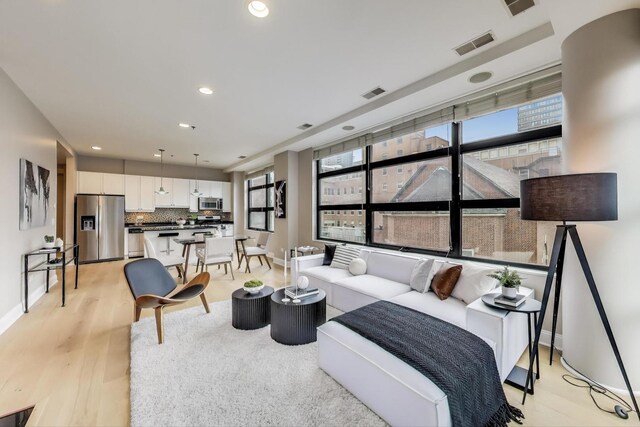 101 W Superior St Unit 501, Chicago, IL 60654 - living room featuring healthy amount of natural light, baseboards, light wood-type flooring, and recessed lighting